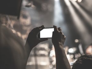 Big brands are adopting live streaming (and you should too)_filming_concert_on_phone